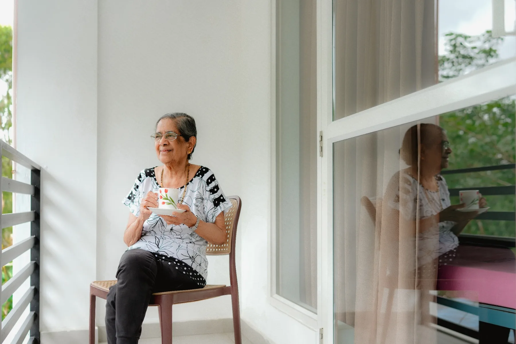 Senior resident enjoying tea on a private balcony