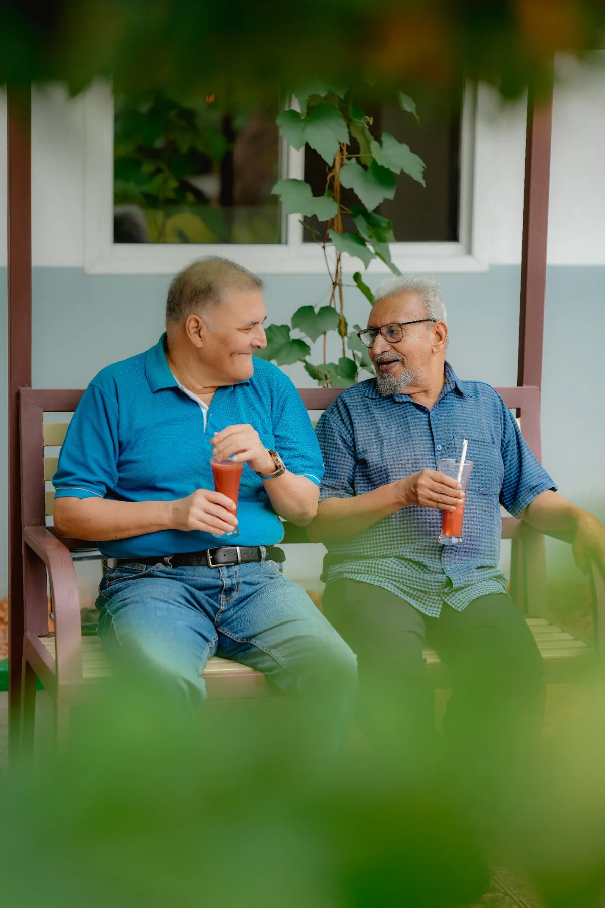 Two senior friends enjoying refreshments outdoors
